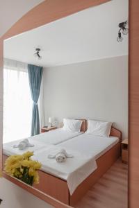 a bedroom with a bed with white sheets and flowers on it at Solea Family Hotel & Restaurant l Free Parking in Ravda +44 photos