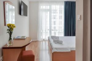 a bedroom with a bed and a table and a window at Solea Family Hotel & Restaurant l Free Parking in Ravda