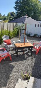 a wooden table and two chairs with an umbrella at Arbor Suite in Greytown