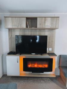 a fireplace in a living room with a tv at St Nicolas in Girvan
