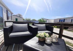 a patio with two couches and a table with flowers at Casa Nature's Avlis Bungalow 4XZ in Pataias +38 photos