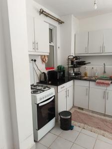 a kitchen with white cabinets and a stove top oven at HM Royal Homes in Nairobi