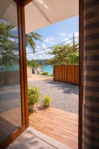 an open door to a patio with a view of the ocean at Surf Villa Hiriketiya in Hiriketiya