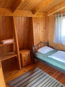 a room with a bed in a wooden cabin at Domek z bali in Wojcieszyce