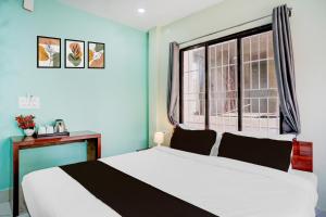 a bedroom with a white bed and a window at Hotel O The Pride Inn Basistha Road in Khānāpāra
