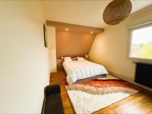 a bedroom with a bed and a window and a rug at Villa Margil in Le Tréport
