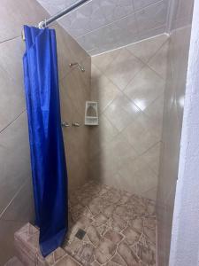 a shower with a blue shower curtain in a bathroom at Villa Luis in Boquete