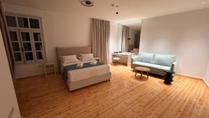 a bedroom with a bed and a couch and a chair at Epos by the Sea in Larnaca