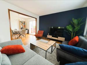 a living room with a couch and a tv at Villa Margil in Le Tréport