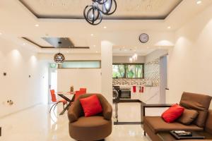 a living room with two chairs and a table and a kitchen at Aion Suites 301 in North Legon