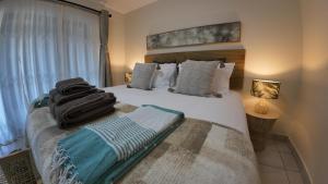 a bedroom with a large bed with pillows at Ebb & Flow Beach House in Oyster Bay
