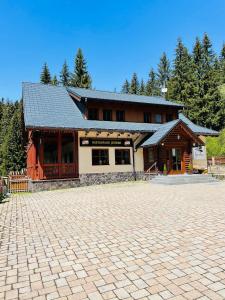 a large building with a brick driveway in front of it at Jezírko lesní restaurant & penzion in Jáchymov