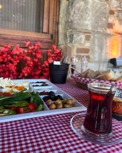 a table with a plate of food and a drink at Bademli Ancanoz Hotel in Dikili