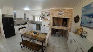 a kitchen with a table and a brick fireplace at Ebb & Flow Beach House in Oyster Bay