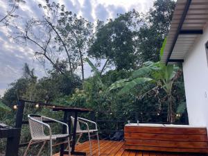 a patio with a table and chairs and trees at Cabañas La Arboleda in La Vega
