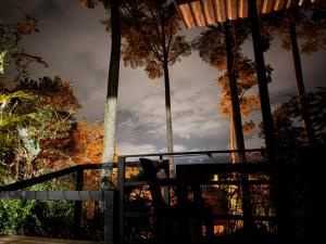 a bench in front of a fence with trees at Cabañas La Arboleda in La Vega +2 photos