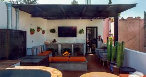 a patio with a fireplace and a couch and a fire place at Casa Callejon in San Miguel de Allende