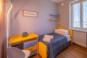 a small bedroom with a yellow bed and a desk at A Casa di Beppe a Monforte dAlba in Monforte dʼAlba