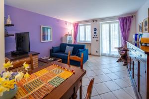 a living room with a blue couch and a table at A Casa di Beppe a Monforte dAlba in Monforte dʼAlba