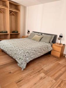 a bedroom with a large bed and a wooden floor at La Ca' nel Borgo in Tenno