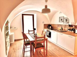 a kitchen with a table and chairs in a room at La Ca' nel Borgo in Tenno