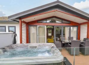 a house with a hot tub on a patio at Honeysuckle lodge in Abergele +7 photos