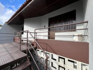 a balcony of a house with metal railing and stairs at Studio moderno com ar condicionado central in Aracaju