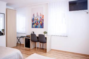 a bedroom with a desk and two chairs at Rooms Ikar in Velika Gorica