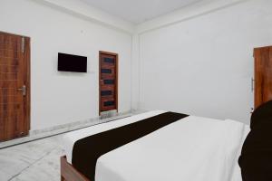 a bedroom with a bed and a television on a wall at Hotel O The Skyrise Lucknow Hotel in Lucknow +31 photos