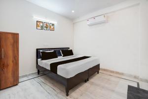 a bedroom with a bed and a wooden cabinet at Hotel O The Skyrise Lucknow Hotel in Lucknow