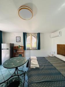 a room with a bed and a table and a window at Lemontree House Bacoli in Bacoli