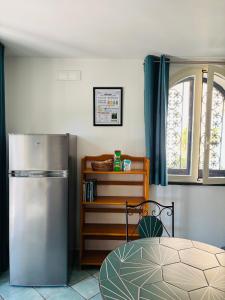 a kitchen with a stainless steel refrigerator and a window at Lemontree House Bacoli in Bacoli