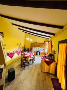 a living room with a table and chairs and a kitchen at Santa Ittoria in Cossoine