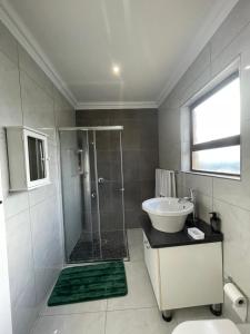 a bathroom with a glass shower and a sink at Villa Amari in Aliwal North +4 photos