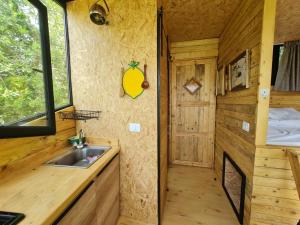 a kitchen with a sink in a tiny house at MONKEY MANSION - Luxury Treehouse - Private Escape with outdoor hot Tub in Abū Mīzān
