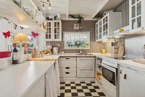 a kitchen with white cabinets and a checkered floor at KATs FRISTED in Ebeltoft
