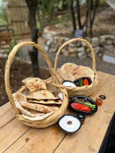 a basket of bread and vegetables on a wooden table at MONKEY MANSION - Luxury Treehouse - Private Escape with outdoor hot Tub in Abū Mīzān +43 photos