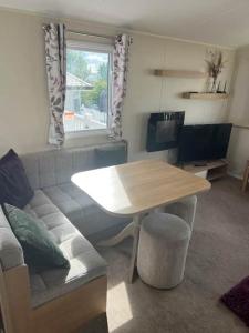 a living room with a table and a couch at Devon Cliff Breaks in Exmouth