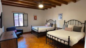 a living room with two beds and a chair at Casa Callejon in San Miguel de Allende