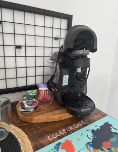 a black coffee maker sitting on a cutting board at Bogota in Laon