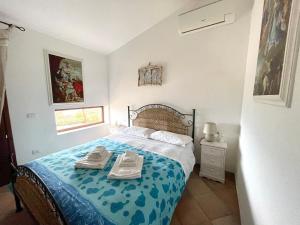 a bedroom with a bed with two shoes on it at Villa La Dolce Vista & Private hydro pool in Costa Paradiso +51 photos