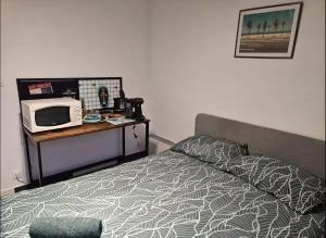 a bedroom with a bed and a microwave on a table at Bogota in Laon