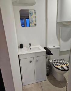 a white bathroom with a sink and a toilet at Bogota in Laon