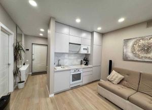 a living room with a couch and a kitchen at Ривер люкс Днепр in Dnipro +15 photos