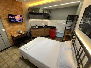 a small room with a bed and a kitchen at Studio moderno com ar condicionado central in Aracaju