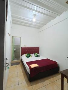 a bedroom with a bed in a white room at PTS Homestay Syariah in Bandung