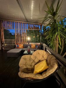 a couch with a yellow pillow sitting on a porch at Monte do Bidé Private Farm Peace and Nature in Setúbal +28 photos