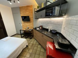 a small kitchen with a sink and a microwave at Studio moderno com ar condicionado central in Aracaju