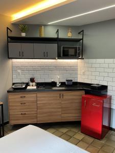 a kitchen with a red refrigerator and a microwave at Studio moderno com ar condicionado central in Aracaju +5 photos