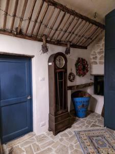 a grandfather clock in a room with a blue door at Casa Fonte Vallone in Pacentro